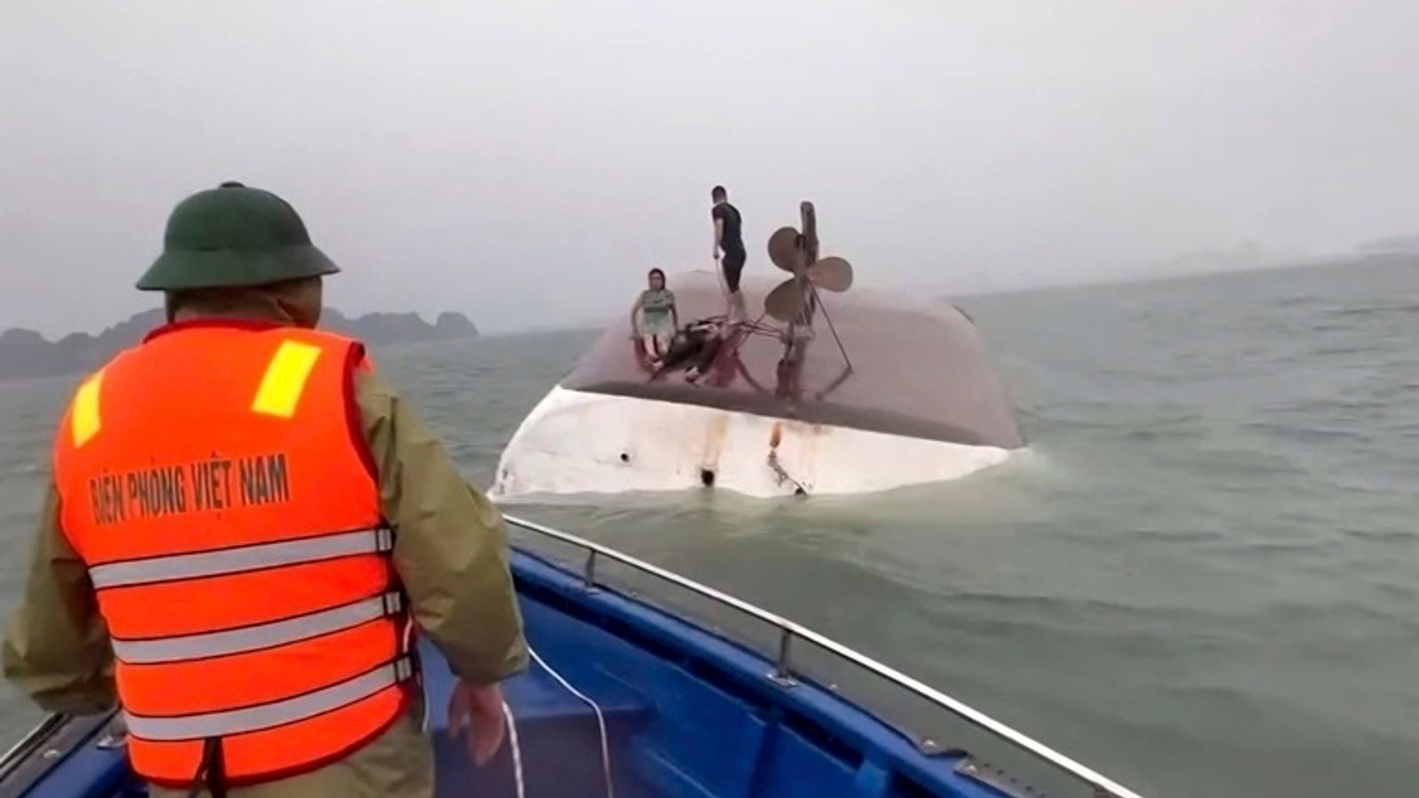 People on a capsized tourist boat being rescued in Ha Long Bay, Vietnam. Pic: QDND via AP