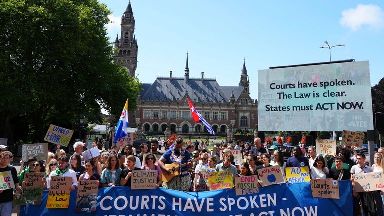 Activists demonstrate outside The Peace Palace, housing the International Court of Justice, ahead of an advisory opinion on what legal obligations nations have to address climate change and what consequences they may face if they don't, Wednesday, July 23, 2025, in The Hague, Netherlands. (AP Photo/Peter Dejong)