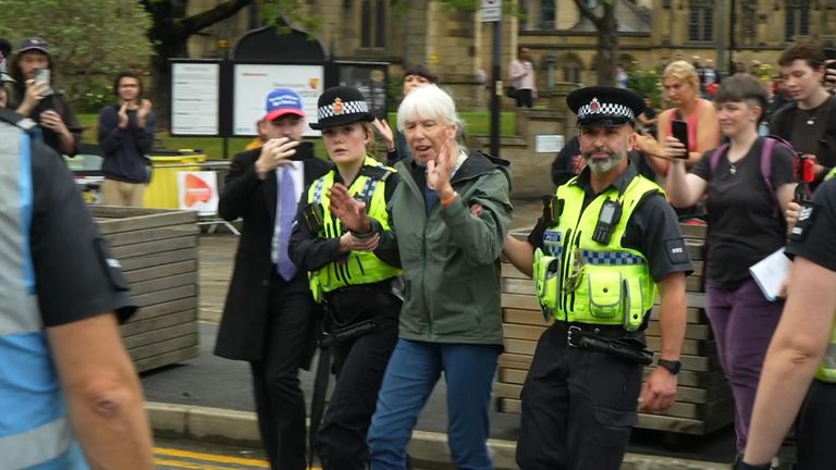 A woman is led away by police in Manchester