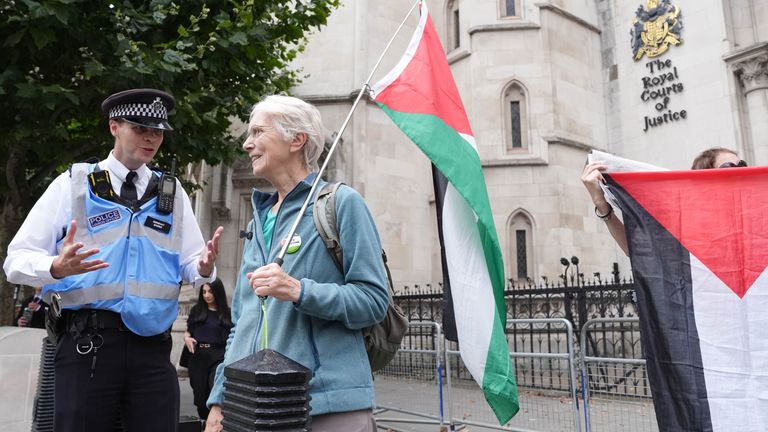 A police liaison officer speaks with a campaigner outside The Royal Courts Of Justice.
Pic: PA