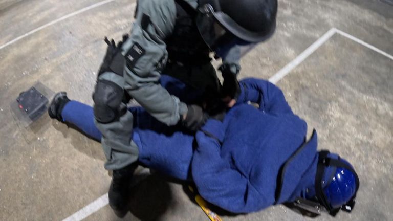 An 'inmate' is tackled by a security officer during a role-play demostration