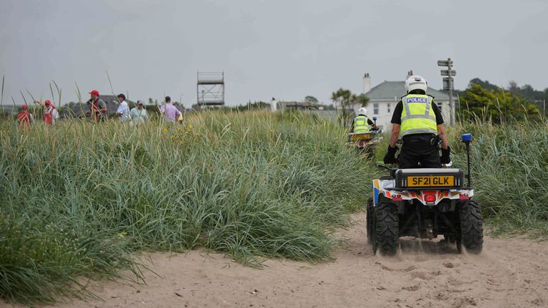 Police on buggies patrol as golfers play, near the Trump Turnberry golf course