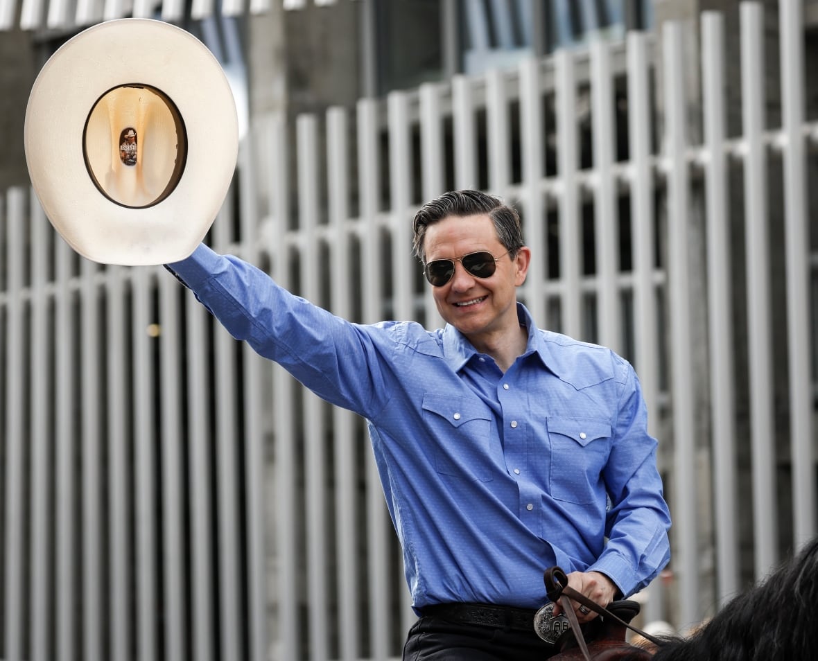 Conservative Leader Pierre Poilievre waves to the crowd as he rides in the Calgary Stampede parade in Calgary, Alta., Friday, July 4, 2025.