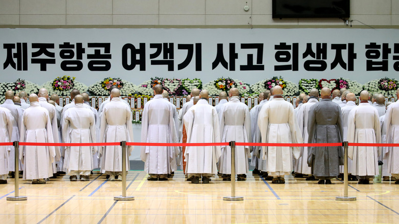 South Korean monks pay tribute at a group memorial altar for victims of Flight 7C2216 at the Muan sport park December 30, 2024 in Muan-gun, South Korea.