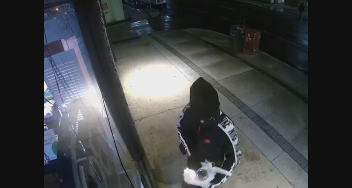 a person gets ready to throw a Molotov cocktail inside a restaurant