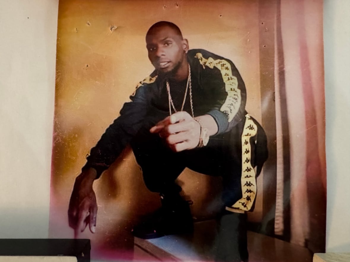 Man in matching workout gear points his index finger while crouching down
