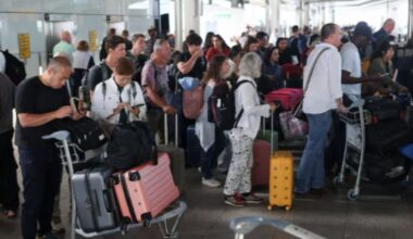 Passengers stand with their luggage, after radar failure led to the suspension of outbound flights across the UK,