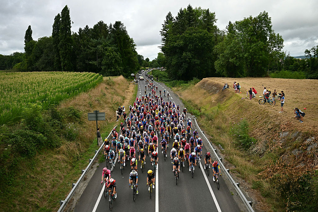 The pack of riders (peloton) cycles cycles during the 14th stage of the 112th edition of the Tour de France cycling race, 182.6 km between Pau and Luchon-Superbagneres, in the Pyrenees mountains of southwestern France, on July 19, 2025. (Photo by Loic VENANCE / AFP)