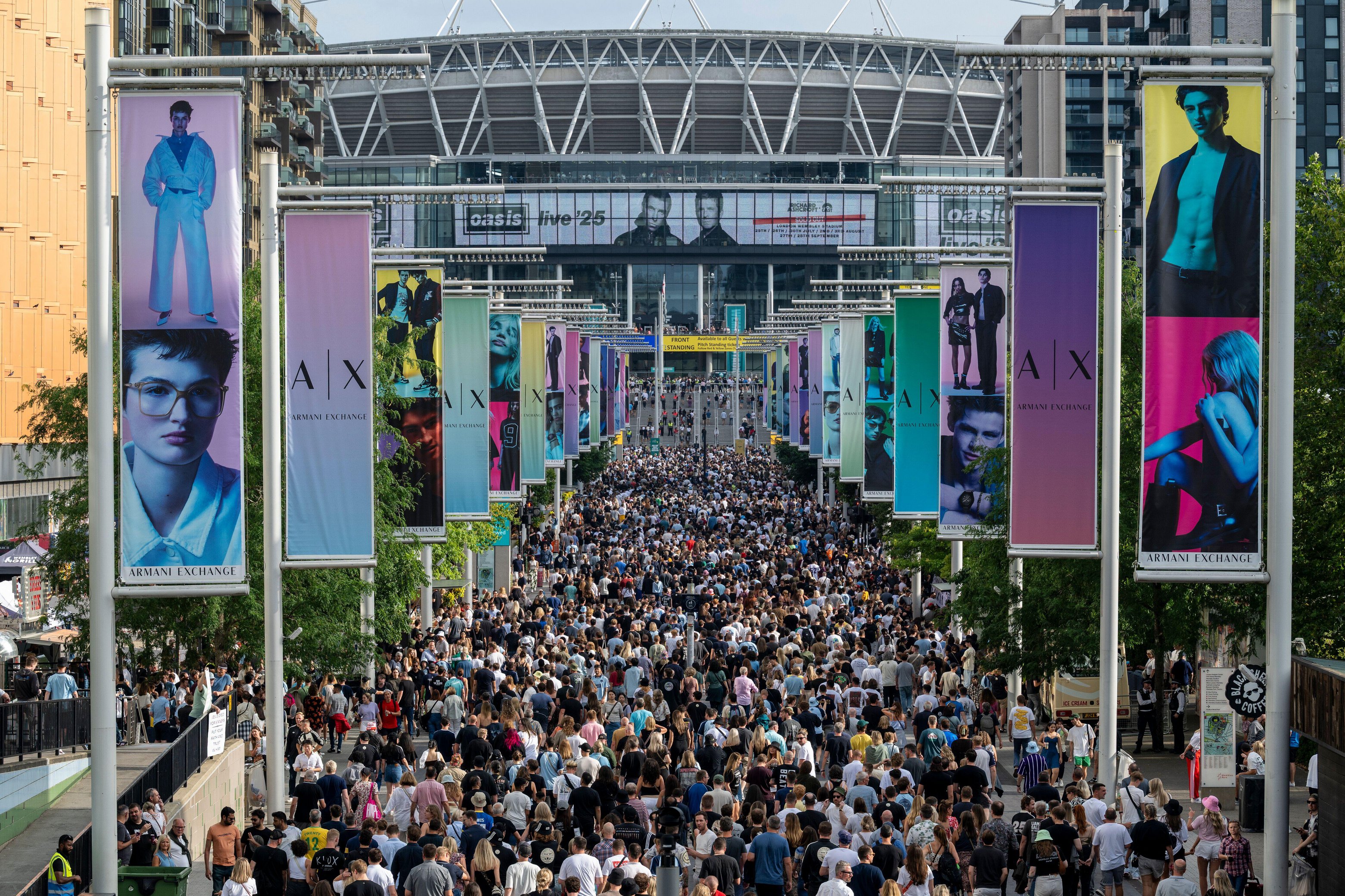 London, UK. 25 July 2025. Fans on Olympic Way arrive for tonight?s Oasis concert at Wembley Stadium, the first time that the band has played in the capital for 16 years. The band will play seven dates across July to September at Wembley Stadium as
