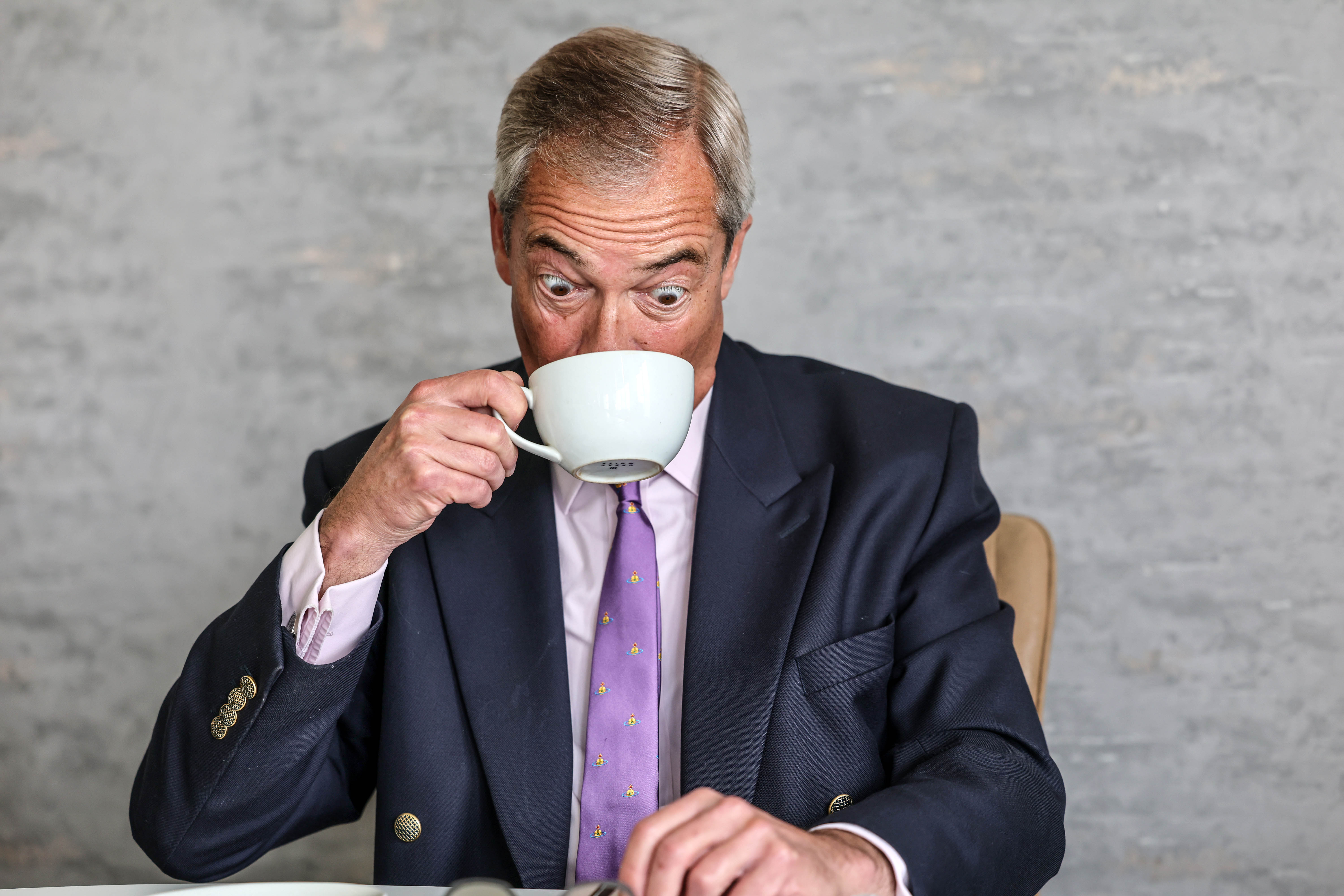 Nigel Farage drinking from a cup during an interview.