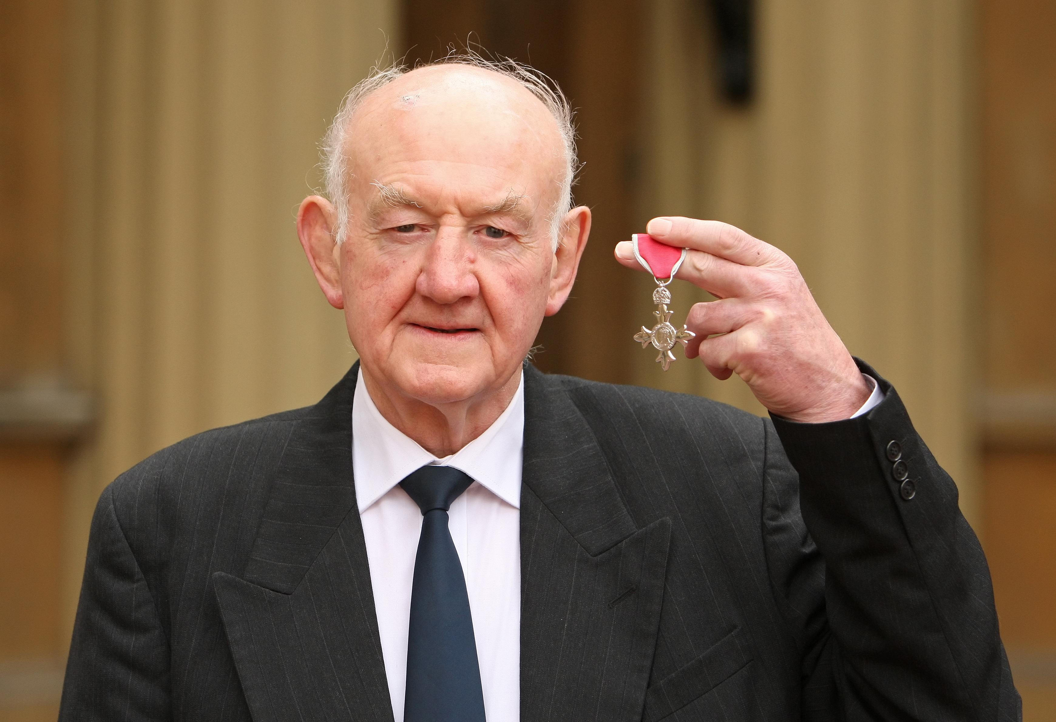 Ray French displaying his MBE medal at Buckingham Palace.