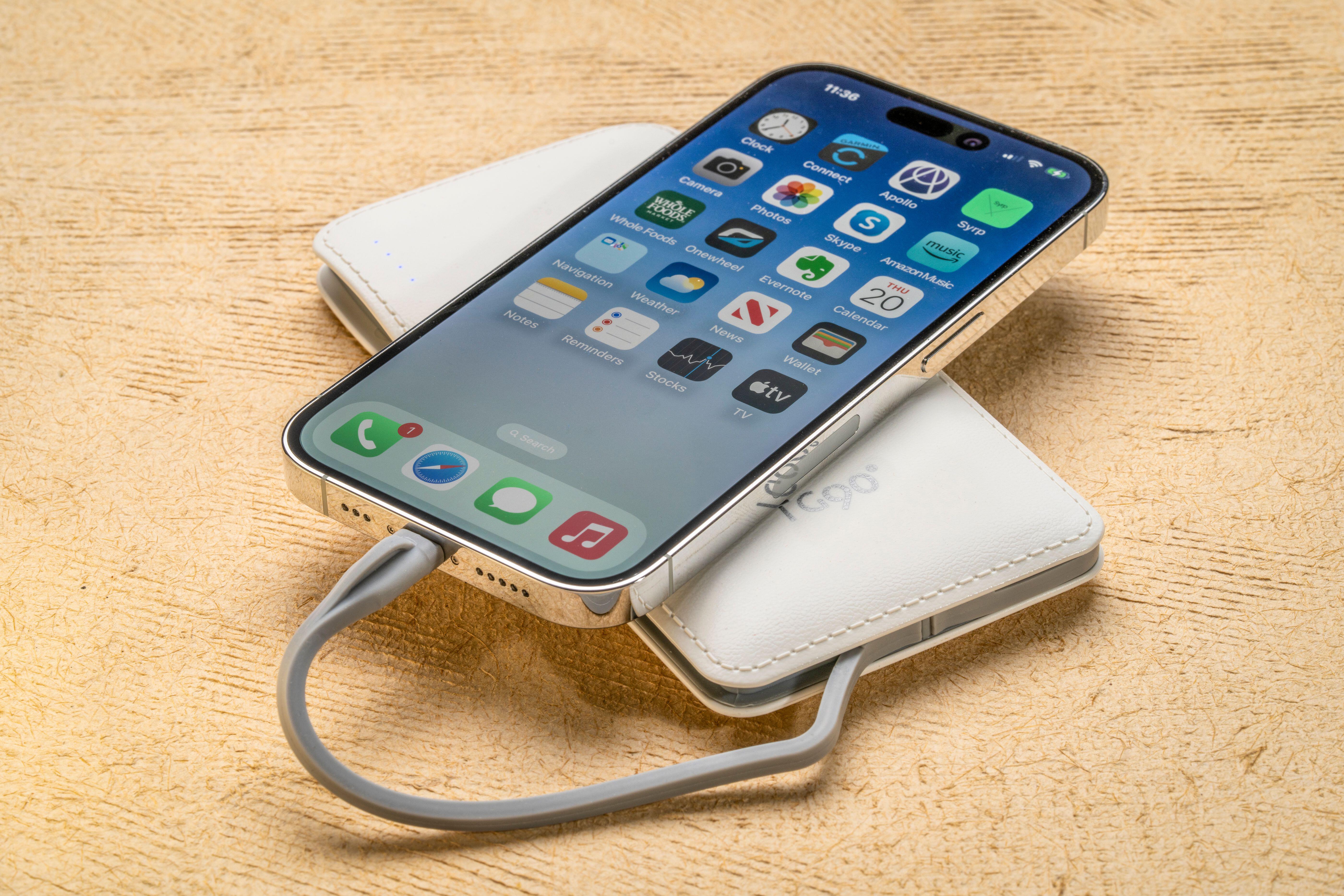 iPhone 14 Pro charging from a portable battery pack.