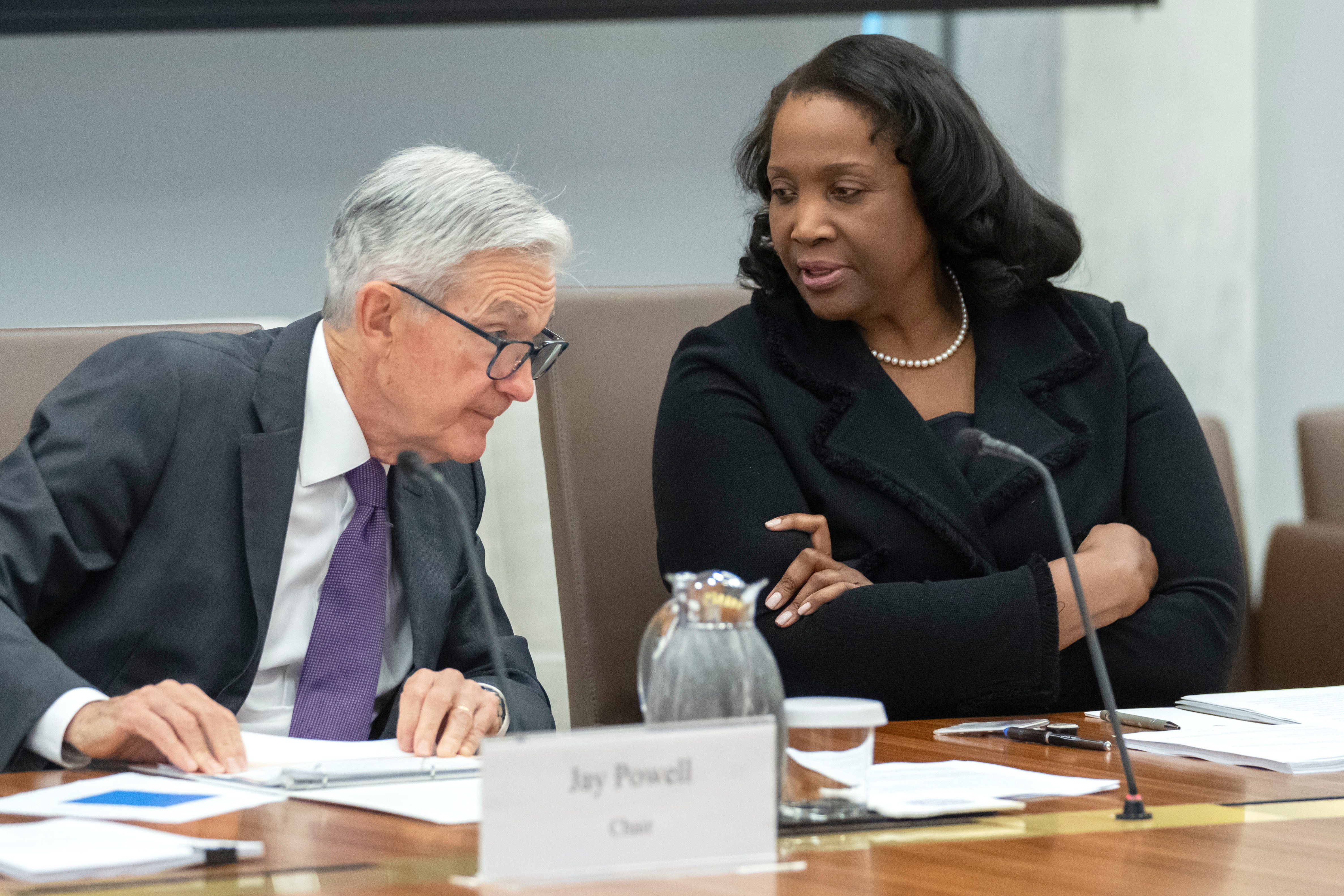 Lisa Cook and Jay Powell in discussion at a Federal Reserve meeting.