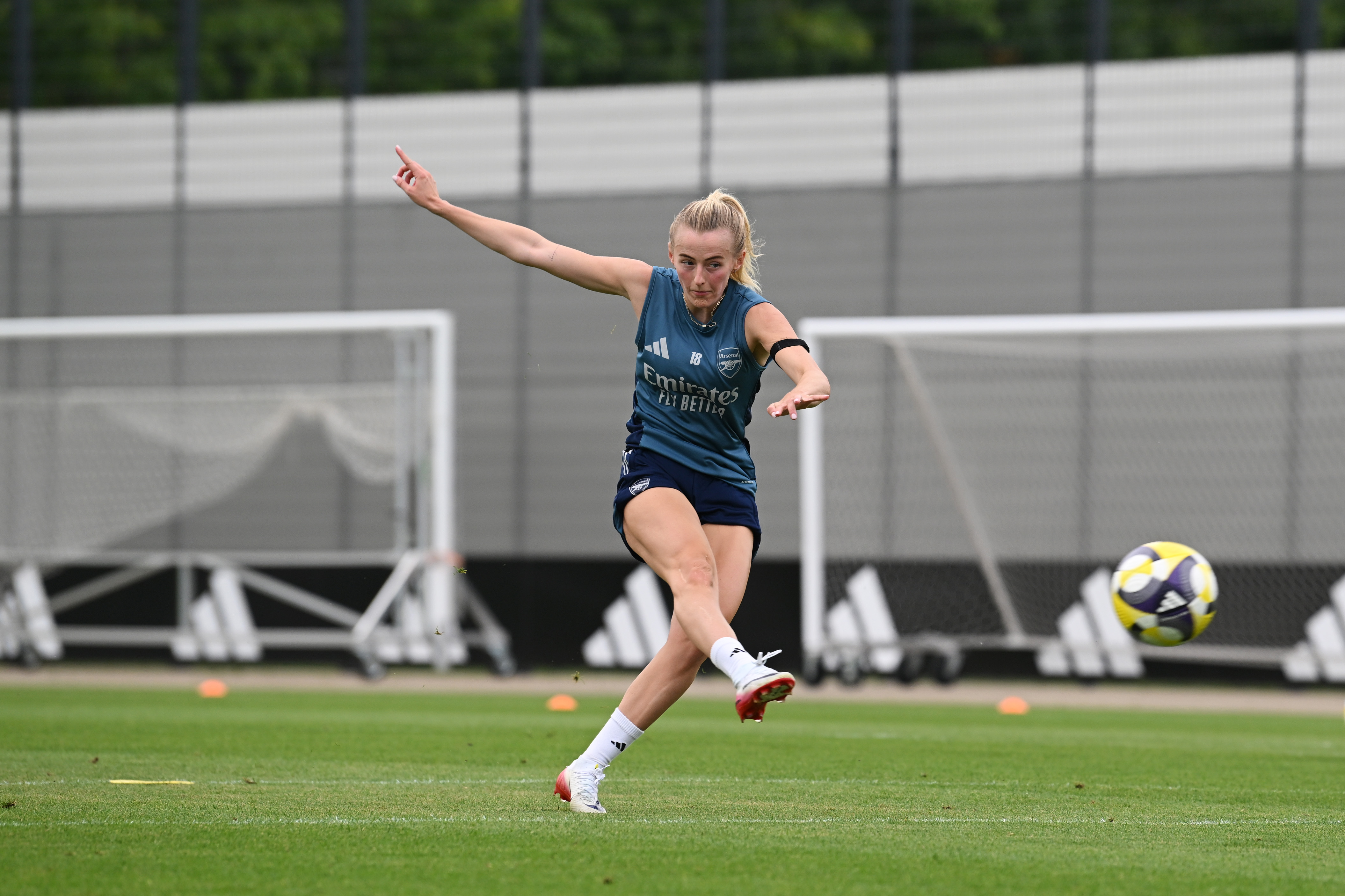 Chloe Kelly of Arsenal Women kicking a soccer ball during training.
