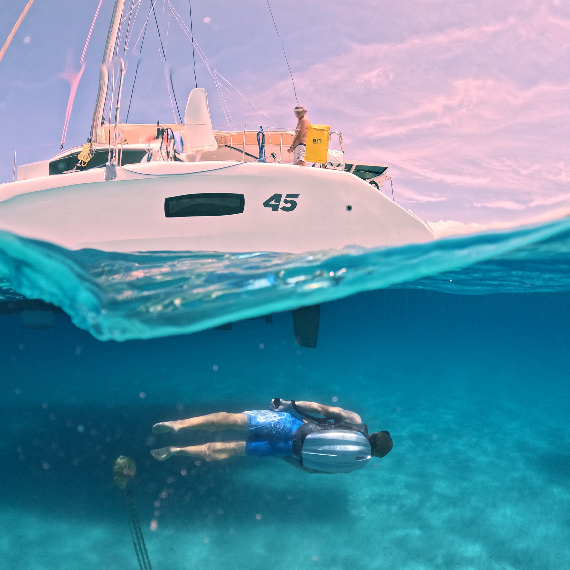 Person using a Cudajet underwater jetpack near a catamaran.