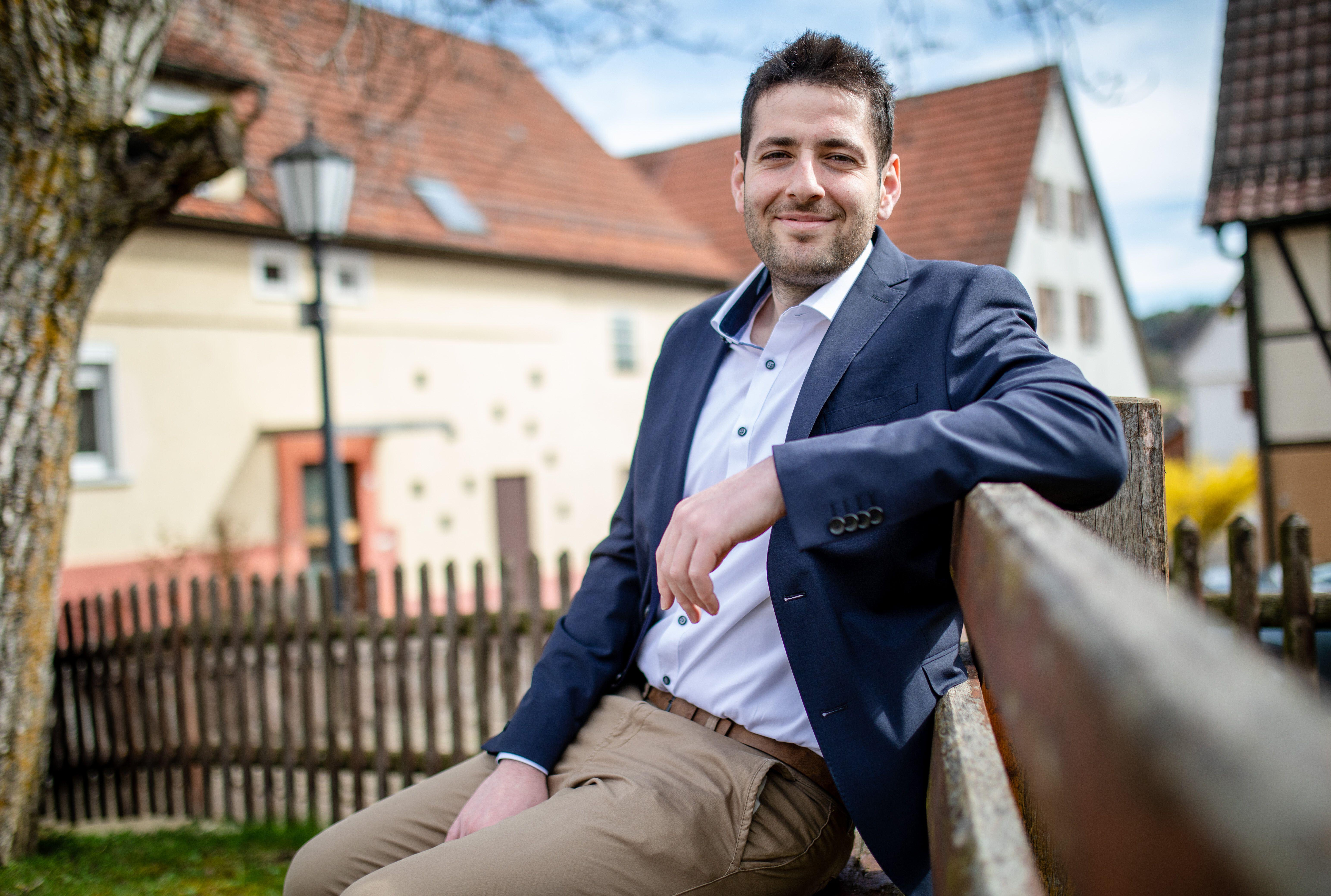 Ryyan Alshebl, a Syrian refugee, sitting on a bench in Ostelsheim, Germany. He is running for mayor.