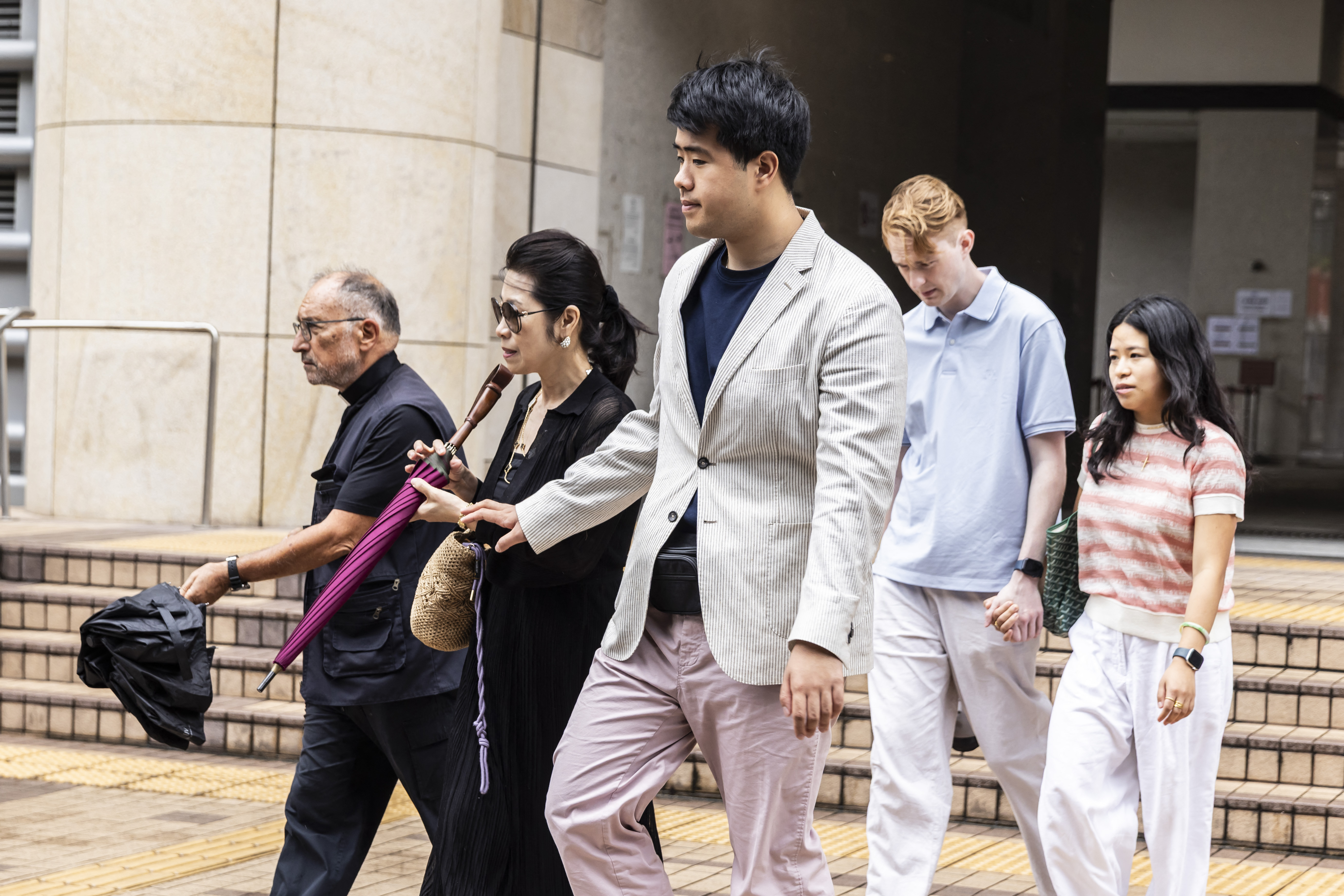 Jimmy Lai's wife and son leaving the West Kowloon court in Hong Kong.