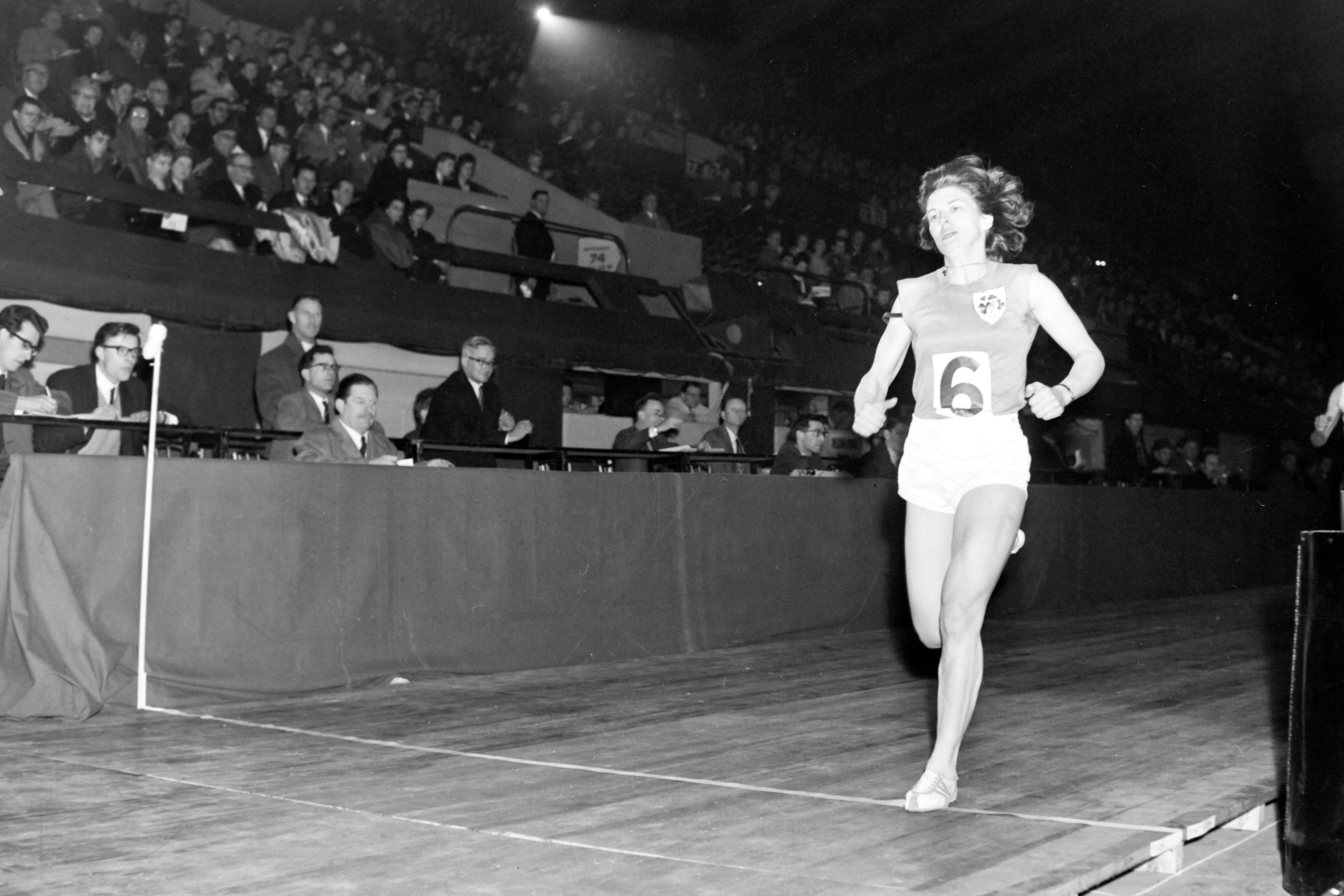 Black and white photo of athlete Maeve Kyle winning a race.
