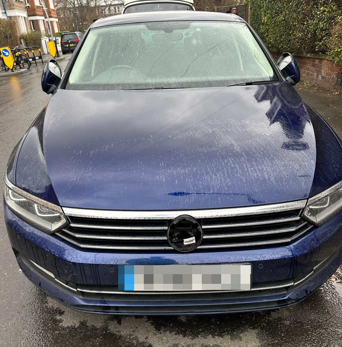 A dark blue car with its emblem missing.