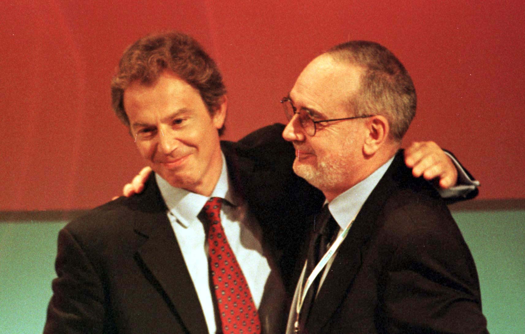 Photo of Tony Blair embracing Tom Sawyer at a Labour Party conference.
