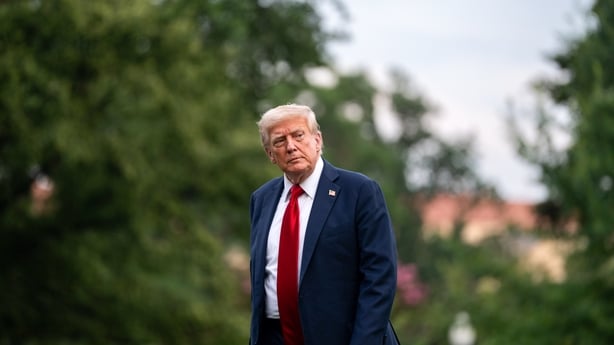 US President Donald Trump walks along the South Lawn of the White House 
