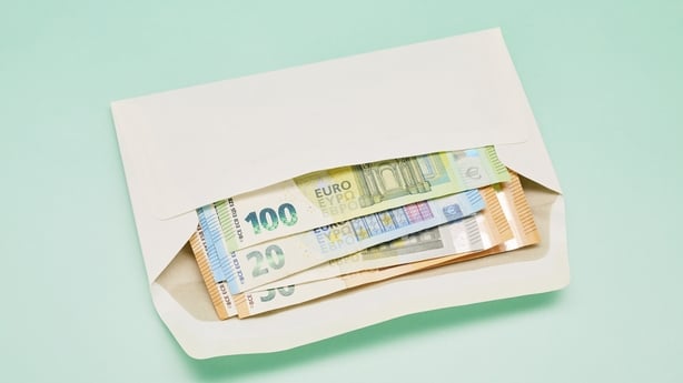 Still life of a bunch of Euro banknotes in an envelope on turquoise background