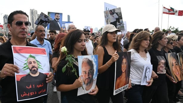 Lebanese demonstrators carry portraits of the victims of the catastrophic port explosion in 2020