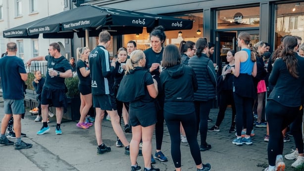 people stand outside a coffee shop chatting