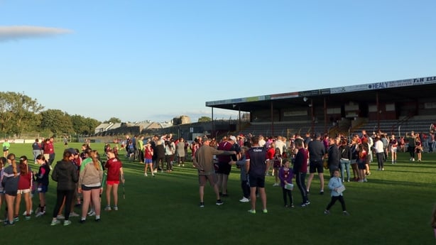 Galway fans are gathered on the pitch to watch the camogie team train in Athenry