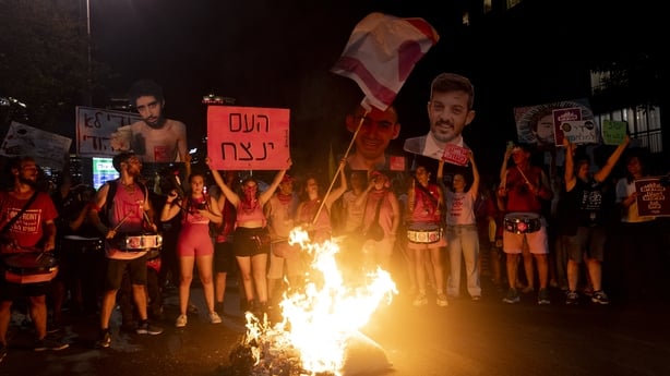  Protesters set a fire as they hold photos of hostages held in the Gaza Strip during a protest calling for a hostages deal on August 7, 2025 in Tel Aviv, Israel. Local media reports that Israeli Prime Minister Benjamin Netanyahu is seeking backing from his security cabinet for the 