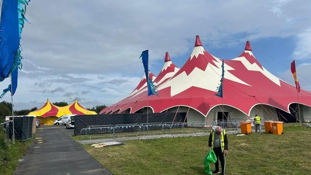 A man is seen in front of a big top 