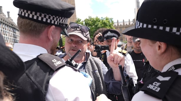 A man points his finger at two police officers in London