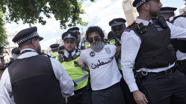 A man is led away by police officers in London