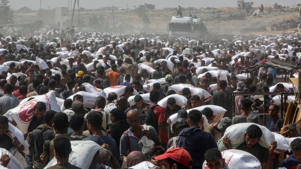 Hundreds of people carrying bags of food in Khan Younis, Gaza