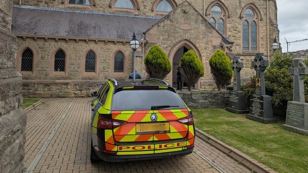 A police car is seen in the grounds of a church