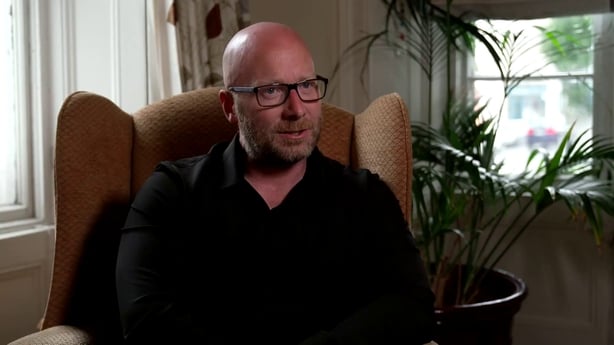 A man being interviewed with glasses