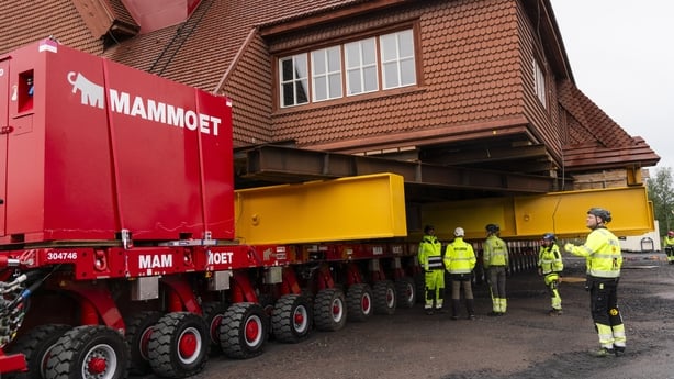 A large red building sits on top of trailers