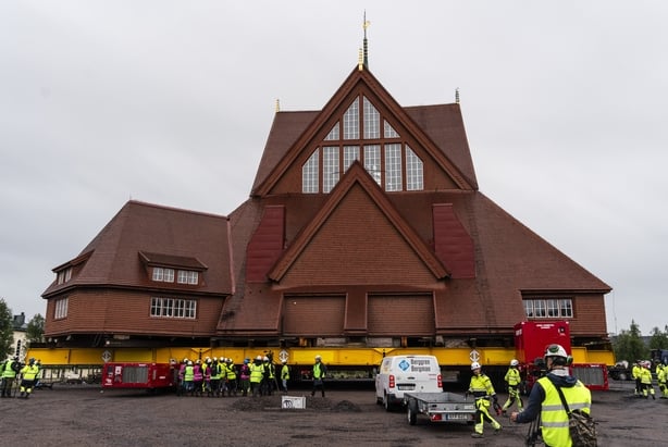 A large red building sits on top of trailers