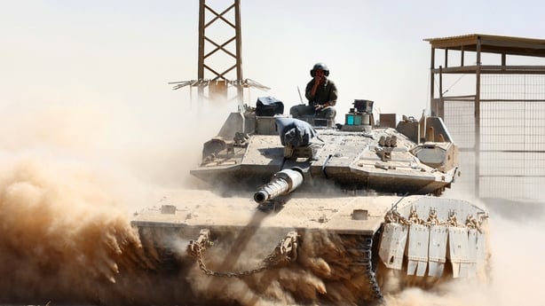 Israeli troops drive a tank near Israel's border fence with Gaza
