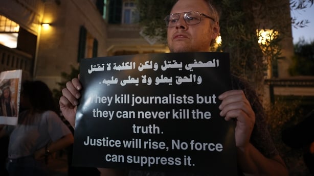 a man holds a banner calling for the end to the war in gaza in haifa, israel