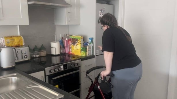 Nikita Clarke using a walker in her home due to her condition