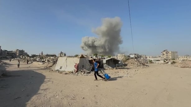 Smoke is seen billowing over a desolate landscape