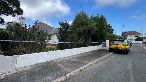 a police car in front of a house with a crime scene tape 