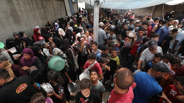 People crowd tightly together to queue for food in Gaza