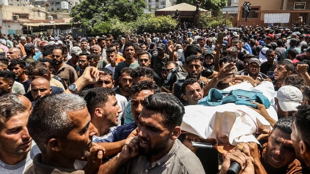 Image shows crowds at a funeral ceremony in the courtyard of Nasser Hospital for journalists Hossam al-Masri, Mohammed Salameh and Maryam Abu Deqqa