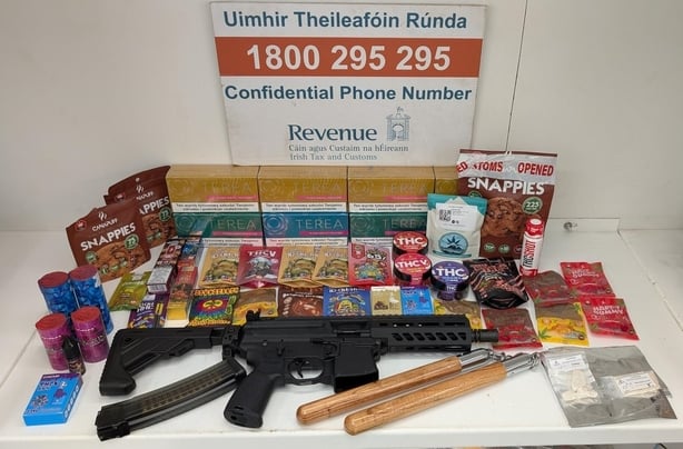 A display of a variety of drugs, weapons on a table with a revenue sign