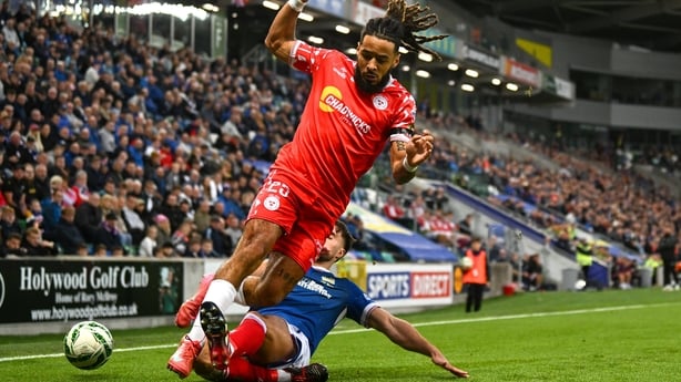28 August 2025; Milan Mbeng of Shelbourne is tackled by Euan East of Linfield during the UEFA Conference League Play-off Round second leg match between Linfield and Shelbourne at the Clearer Twist National Football Stadium at Windsor Park in Belfast. Photo by Ramsey Cardy/Sportsfile