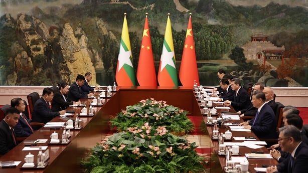 People speak to each other at a long table