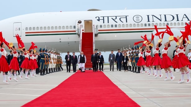 People walk out on the tarmac from an airplane