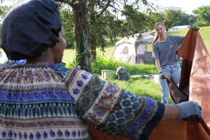 A woman with the Washington Legal Clinic for the Homeless, right, helps a woman who has been living at a tent encampment clear out her items, on Thursday.